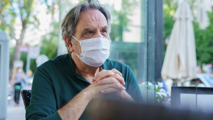 Man looking out window with mask