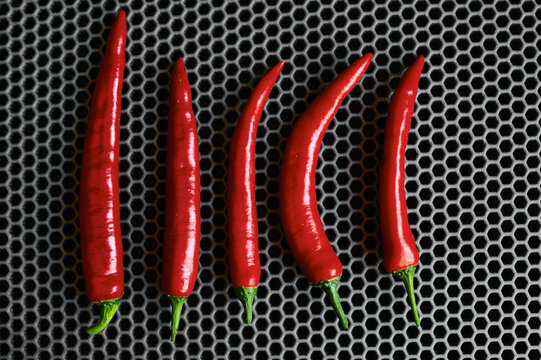 red sharp chili peppers vertically top close up against a dark background 