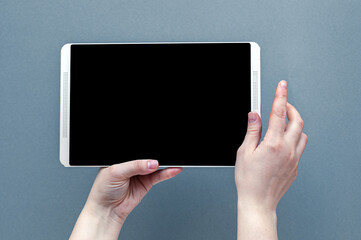 Woman hands holding contemporary generic tablet pc with blank screen.