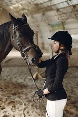 Obraz premium Woman near horse. Rider in a black uniform