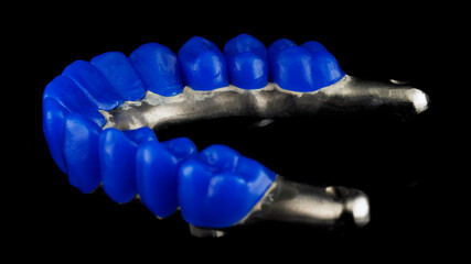 preparation of the manufacture of a dental prosthesis and teeth from wax of the upper jaw. side view on a black background © Dental Pro Content