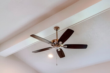 Fototapeta Decorative wood beam with standard ceiling fan and lights inside a house obraz