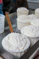 The making of tuma cheese: farmer filling containers with just made tuma cheese