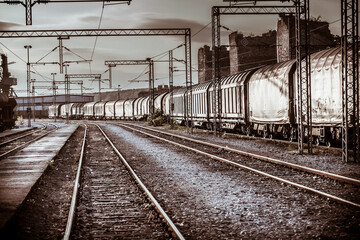 Old railway tracks and cargo train in rustic abandoned station sunset atmosphere