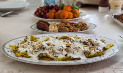 zucchini with yogurt is in focus and the rest of the plates are out of focus. Appetizers and fruits on the table. Ramadan Kareem. Ramadan Iftar table with variety of foods.