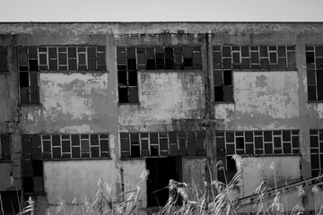 abandoned burned out factory in black and white color. old burned building is looking like a war ruin.