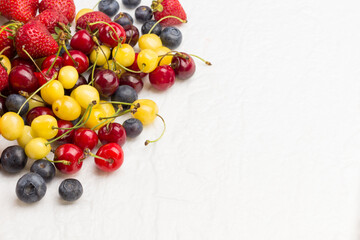 Naklejka na ściany i meble Mixture Apricots with yellow and red cherry, Blueberry Strawberry on white background. Weight loss concept