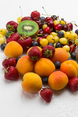 Assorted fresh berries and fruits. Apricots Kiwi Strawberry Cherry Blueberry on white