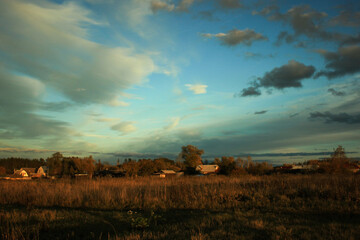 Fototapeta premium summer landscape with village houses and fields at sunset