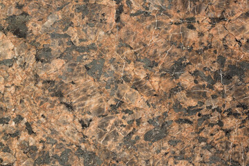 The texture of the rock. Natural stone background. Brown mineral with black spots.