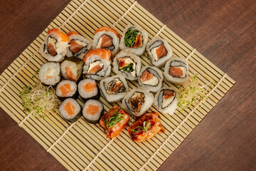 Fototapeta na wymiar Esteira de sushi com ossomaki, uramaki, salmão flambado, philadelphia