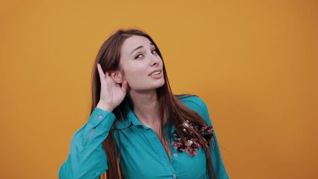 Eavesdropping, espionage, gossip, holding hand near head and looking away, what, relying on hand-ear listening the good news, trying to listen, cupping her ear. Young attractive woman brown hair