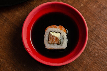 Sushi Joe com salmão cru imerso no shoyu