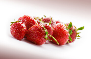 Strawberries stacked fresh colorful arrangement with green leaves close up isolated on white background studio shot