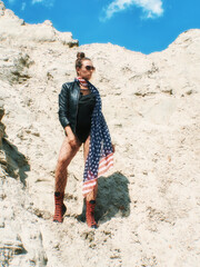 Model Girl with american flag on her neck looking ahead in desert. Copy space.