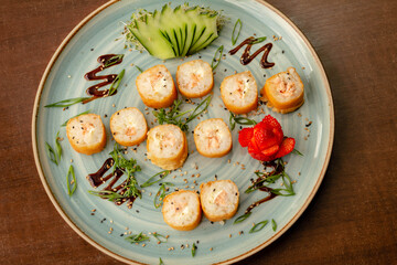 Prato com hot roll de salmão, decorado com pepino e morango
