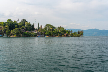 Fototapeta premium The island Samosir and peninsula Tuktuk Siadong with its resorts, within the Lake Toba, the biggest volcanic lake in the world located in the middle of the northern part of the island of Sumatra 