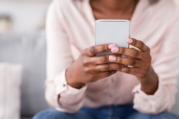 Fototapeta premium Useful App. Closeup of unrecognizable black woman using smartphone at home