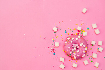 sweet tasty donut with icing and sugar on a pink background with place for text.