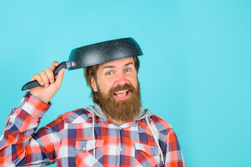 Man with frying pan on head. Crazy bearded chef. Happy man chef with pan. Saucepan. Cooking. Kitchenware. Cooking utensils. Cooking vessels. Kitchen advertising.