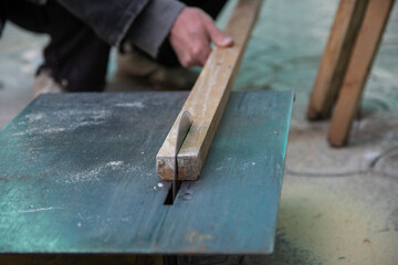 a man saws a bar on a circular saw. Small household machine. High quality photo