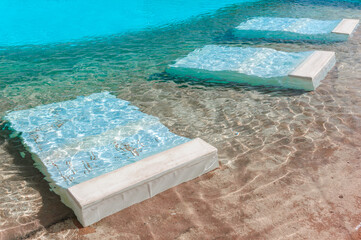 Swimming pool with underwater beds for resting. underwater pool bed