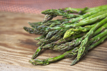 Closeup of a bunch of fresh green asparagus on a wooden board