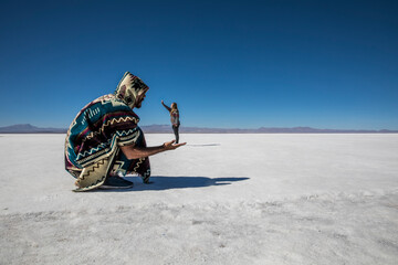 Couple playing with perspective in desert salt flats