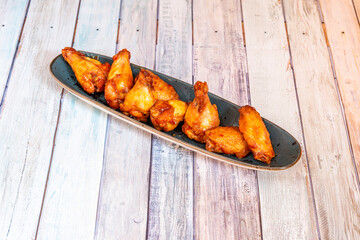 Serving of chicken wings on the wooden table