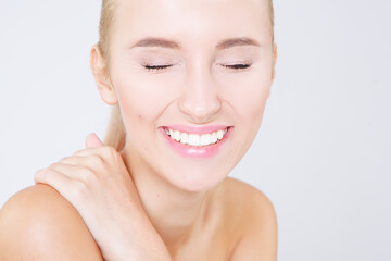Obraz premium Close up portrait of beautiful young happy smiling woman with white teeth, isolated over white background. Natural make-up, perfect skin