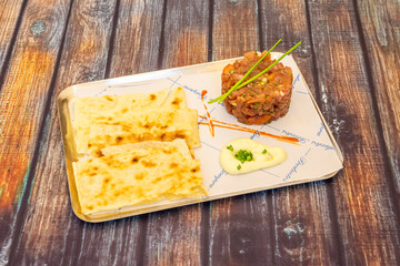 delicious plate of tuna tartar on wooden background