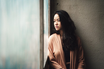 young asian woman portrait feeling calm behind window