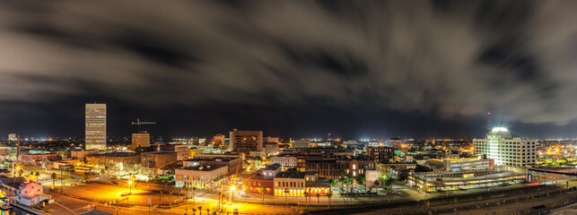 Fototapeta premium Beautiful panoramic aerial view of down town in Galveston, Texas. Long exposure. Night cloudy sky in the background.
