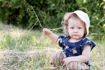 petite fille joue avec les herbes et la terre