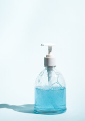 Blue liquid soap in dispenser on light background