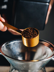 Ground coffee in measuring spoon with filter for brewing