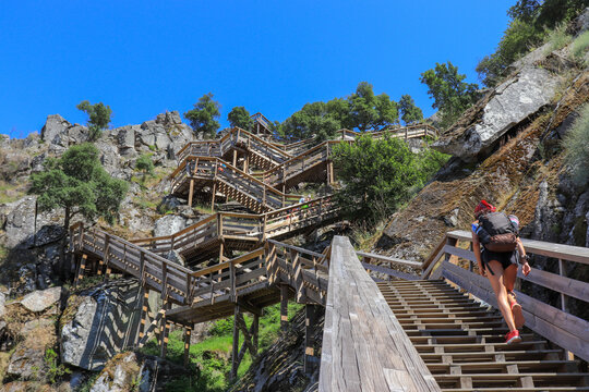 Woman climbing the stairs of Paiva's walkways with backpack
