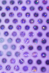 Abstract of lights reflecting on metal grate.