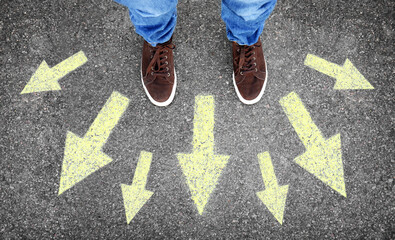 Man standing on road near arrows, top view