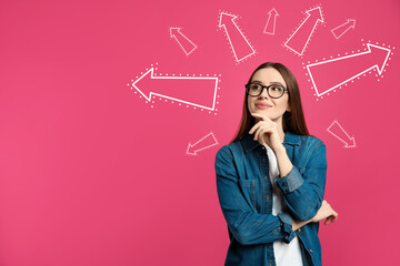 Pensive woman standing near pink wall with arrows, space for text