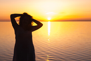 Fototapeta premium girl meets sunrise near the water