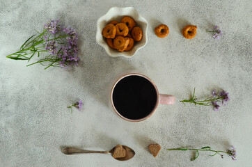 Fototapeta na wymiar Breakfast a сup of coffee, flowers and bagels on the kitchen table