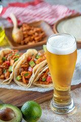 shredded chicken tacos with glass of beer