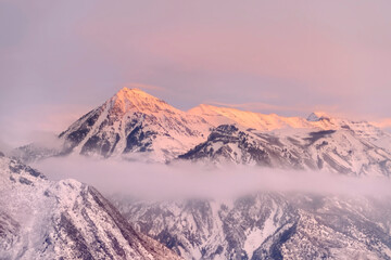 Fototapeta na wymiar Snowy Wasatch Mountains with sharp peaks illuminated by sunset in winter
