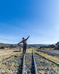 young woman balancing in the railroad