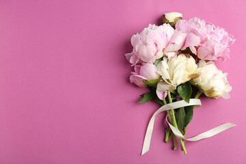 Bouquet of beautiful peonies with ribbon on pink background, flat lay. Space for text
