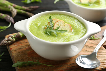 Delicious asparagus soup in bowl served on table