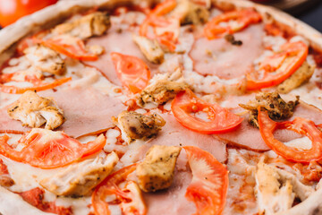 Tasty italian pizza and cooking ingredients tomatoes basil on black concrete background. Hot pepperoni pizza.