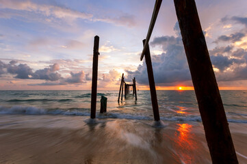 Long exposure image of Dramatic sky seascape with Old wooden pole in the sea sunset or sunrise...