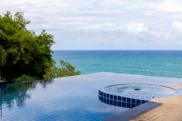 Swimming pool overlooking view andaman sea and clear sky background,summer holiday background concept.